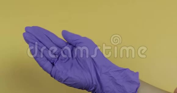 穿着蓝色医用手套的手把大量的药丸放进另一只手视频的预览图