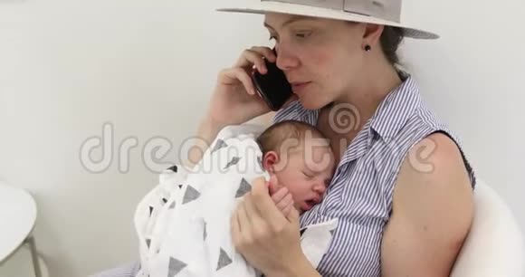 年轻的母亲带着她的孩子用手机说话视频的预览图