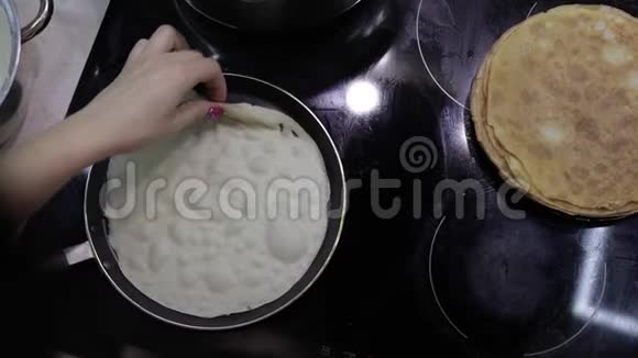 烹饪自制煎饼的过程女人在煎锅里烤煎饼视频的预览图