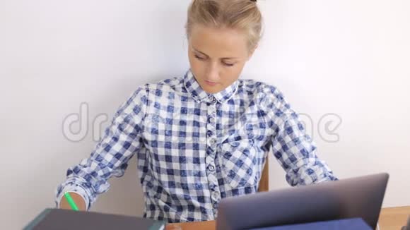 漂亮的女孩在笔记本电脑后面工作写字视频的预览图