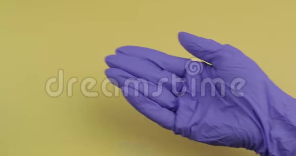 穿着蓝色医用手套的手把一颗白色的圆药丸放进另一只手视频的预览图