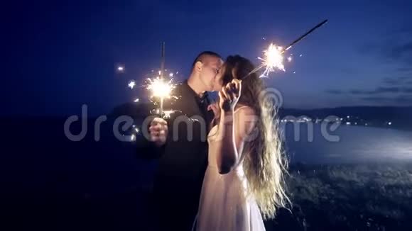 用闪闪发光的灯光亲吻新婚夫妇视频的预览图
