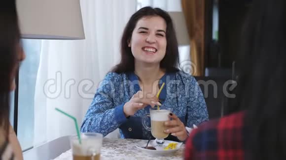 坐在咖啡馆里的年轻女孩有说有笑可爱的女朋友在咖啡馆里玩得很开心视频的预览图