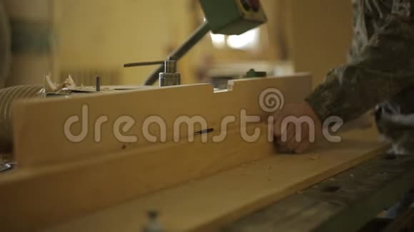 锯木厂的一名工人在一台特殊的机器上加工板材用于切割和加工木材特写和环境视频的预览图