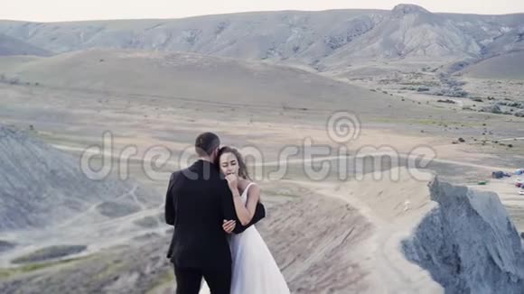 新婚夫妇拥抱在土丘之上视频的预览图