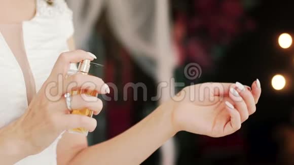 年轻的女士在她的手腕上涂上奢侈的香味闻着选择礼物慢动作关门视频的预览图