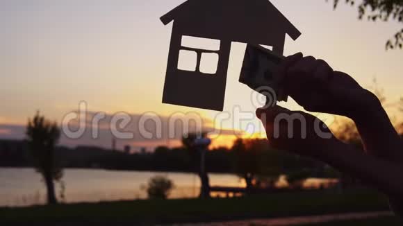 特写镜头的人们把钱放在微型房子的背景上视频的预览图