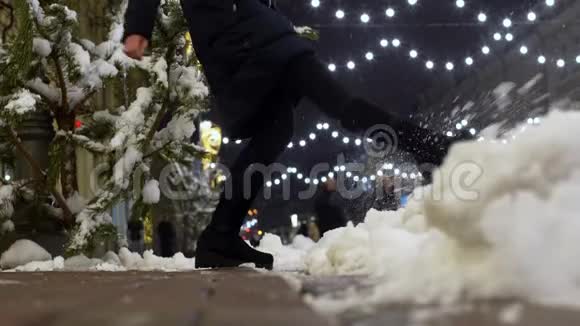 女人的腿在街上踢雪年轻女子的冬季乐趣视频的预览图