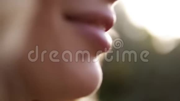特写肖像美女脸吃樱桃一个女人嘴目标镜头户外活动视频的预览图