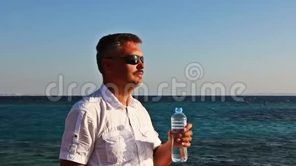男人悠闲地从瓶子里喝水视频的预览图