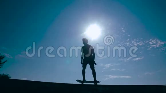滑板运动员剪影滑板在天空背景日落慢动作视频的预览图