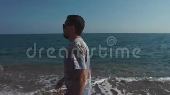 在阳光明媚的夏日放松的人正在沙滩上散步后景视频的预览图