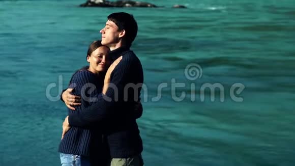 两个情人在蓝水的背景下拥抱视频的预览图