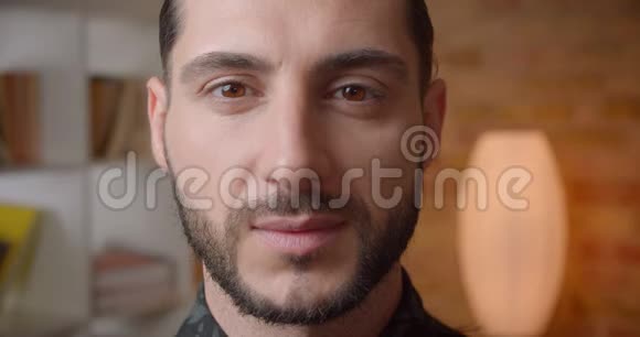 一张年轻迷人的穆斯林胡须男脸在室内看镜头的特写镜头视频的预览图