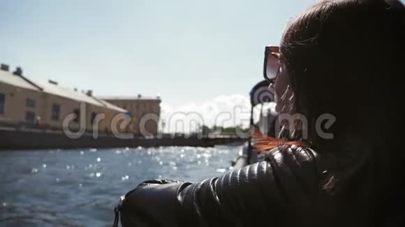 一位年轻女子在城市的河边电车旅行理念旅游休闲活动视频的预览图