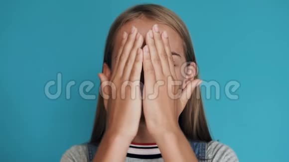 一个年轻漂亮的白种人女孩穿着t恤的肖像在蓝色背景下惊叫哇休克的处女视频的预览图