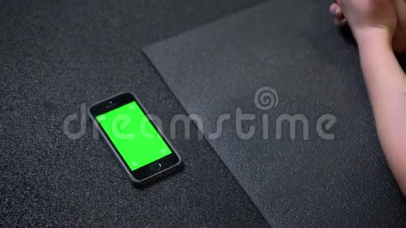 这款手机在健身房的Karrimat附近有着彩色绿色屏幕视频的预览图
