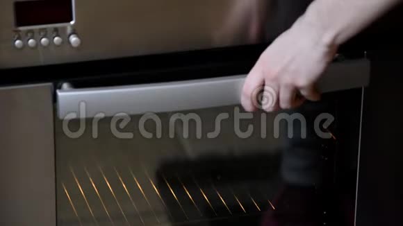 在家做饭在烤箱里烤厨房里漂亮的女孩把蛋糕放进烤箱里视频的预览图