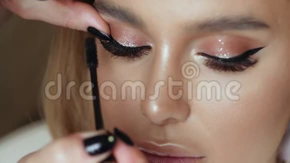 化妆师用一个年轻女人做化妆睫毛视频的预览图