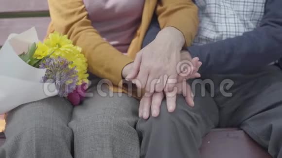 一个老女人紧紧地握住老人的手成熟的人的手成人夫妇视频的预览图