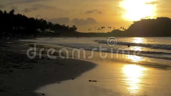 日落时软波在局部海水海滩上冲刷夕阳西下沙滩上海面上一片片平静太阳视频的预览图