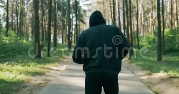 一个人在树林里的小路上穿过松林的慢镜头跑步训练健身和练习视频的预览图