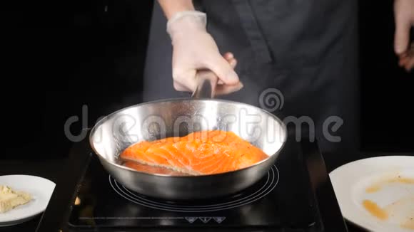 餐厅烹饪专业厨师精致的餐饮理念男性手拿着煎锅上面有鳟鱼片高清高清视频的预览图