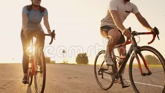 日落时分一男一女在高速公路上骑着运动自行车装备齐全戴着防护头盔动作缓慢时速120英里视频的预览图