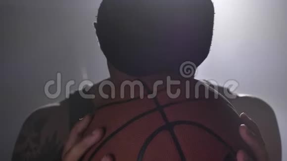 帅气的篮球运动员拿着球看着镜头一个纹身刺耳的男人视频的预览图