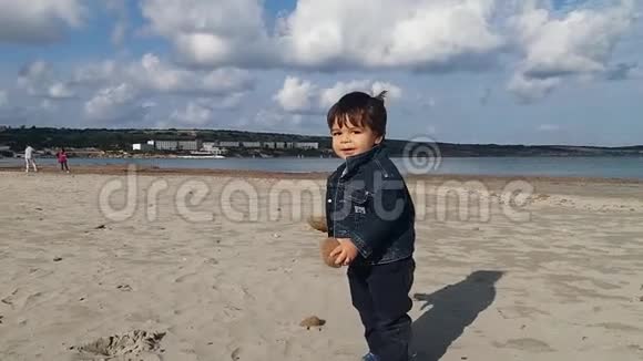一岁半的男婴在沙滩上玩海草球没有人晴天蓝天视频的预览图