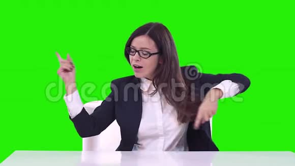 办公室里一个女人绿色背景的肖像布鲁内特笑着跳舞视频的预览图