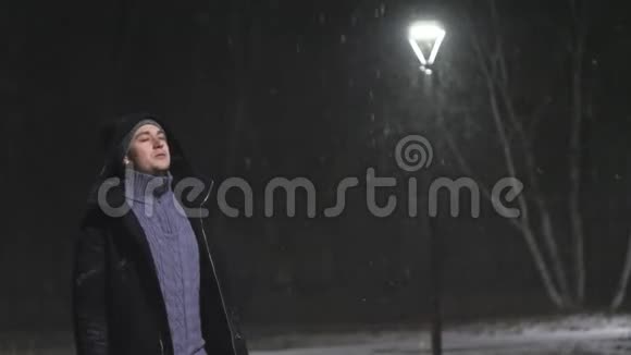 街灯里的那个人在灯的背景下下雪在180fps内缓慢运动雪花真美视频的预览图