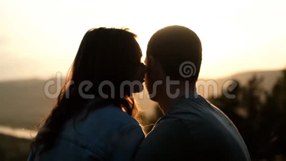 夕阳下一对相爱的年轻夫妇的剪影视频的预览图