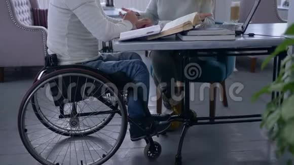 为残疾人提供个人教学教育机构妇女戴眼镜为坐轮椅的残疾人男子提供培训视频的预览图