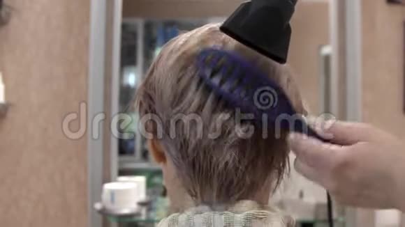 美丽的年轻女子在理发师做头发造型与电吹风热风和梳子视频的预览图