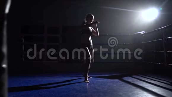 拳王女孩在擂台上拳打脚踢剪影慢动作视频的预览图