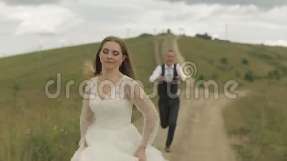 新郎在山上为新娘奔跑新婚夫妇幸福家庭视频的预览图