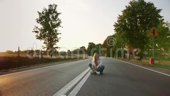 年轻女子在路上自拍可爱的年轻女士微笑着摆姿势自拍坐在欧洲的路上视频的预览图