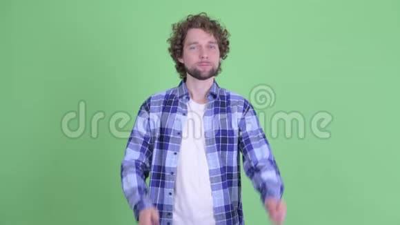 困惑的年轻留着胡子的时髦男人在竖起大拇指和竖起大拇指之间做出选择视频的预览图