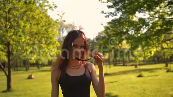 年轻美丽的红发女性在夏天的大自然上戴上墨镜视频的预览图