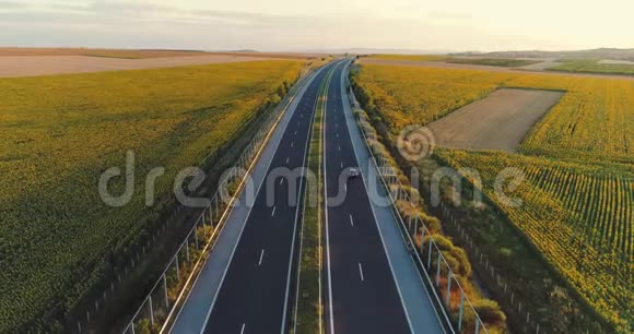 日落时可在高速公路旅行车和农田上空看到空中景色视频的预览图