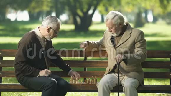 两个老朋友坐在公园的长凳上回忆着年轻的岁月回忆视频的预览图
