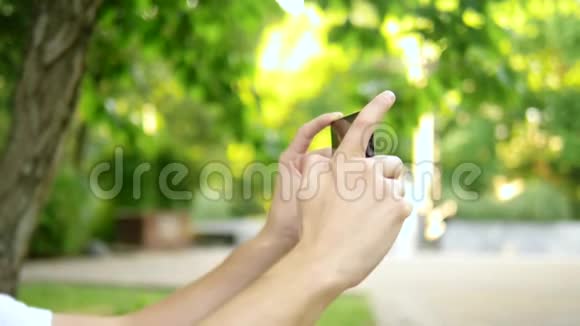 特写镜头一位男性博客作者坐在公园长椅上使用智能手机他有一个视频电话视频的预览图