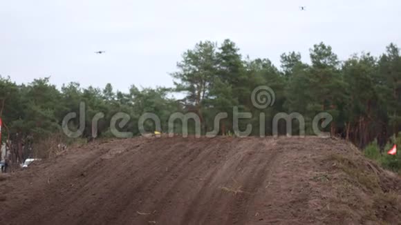 摩托越野比赛摩托车骑在肮脏的赛道上在前景草地和土壤中参与者视频的预览图
