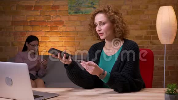 成年女商人在办公室内通过电话在线购物的特写镜头女性雇员使用视频的预览图