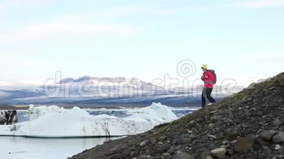 年轻女子背着背包走在冰湖上视频的预览图