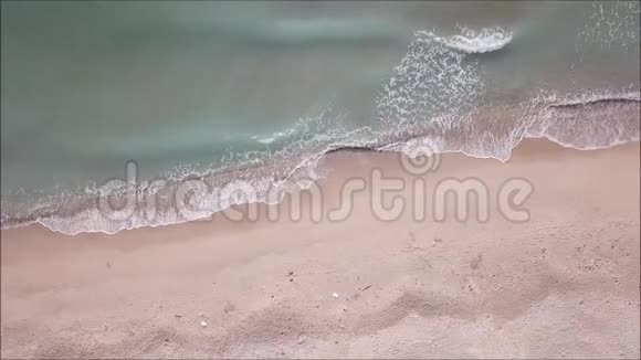 从飞行中的无人驾驶海浪和海滩的高空俯视视频的预览图