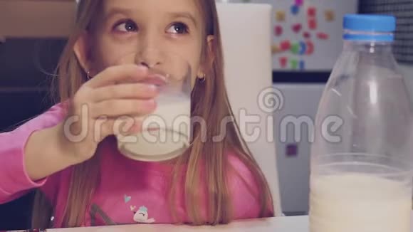 小女孩在家里的厨房里喝牛奶视频的预览图