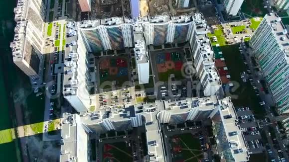 高摩天大楼的空中景观五颜六色的立面有汽车停车位和院子里的儿童游乐场视频的预览图