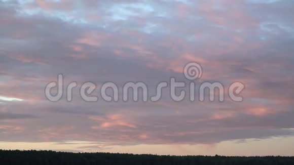 平静的夜晚背景是燃烧的天空和森林五彩缤纷的夕阳天空在大自然中露营视频的预览图